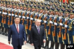 Владимир Путин и Си Цзиньпин на фоне военного почетного караула во время официальной церемонии встречи в Пекине, 16 мая 2024 года.
