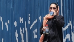 An Iranian woman drinks water during hot weather in Tehran, Iran, 22 July 2024.