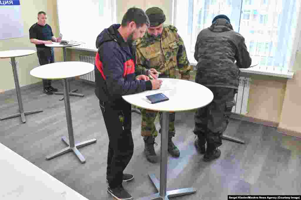 These images from Moscow were taken by photographers from the Kremlin-linked Moskva News Agency and appear to show men signing up for military contracts. The caption on this April 3 photo describes the scene as the “opening of a selection point for contract service.” 