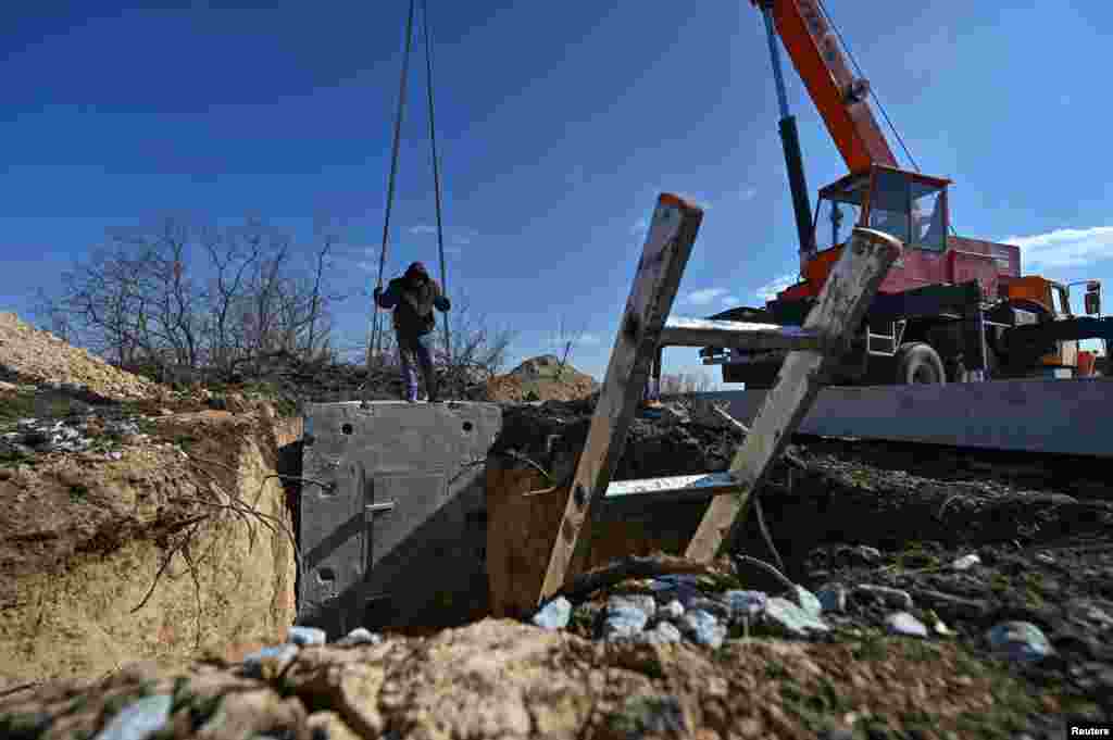 Workers install part of a massive concrete enclosure. Prime Minister Denys Shmyhal reported in January that Kyiv had&nbsp;allocated&nbsp;$466 million for the construction of fortifications, calling it a &quot;record amount.&quot; &nbsp;