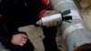A Ukrainian soldier holds a defused cluster bomb from an MSLR missile in Kharkiv on October 21, 2022.