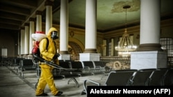 Un lucrător de la ministerul rus pentru urgențe dezinfectează o sală de așteptare de la terminalul feroviar
Kievski din Moscova, imagine de arhivă.