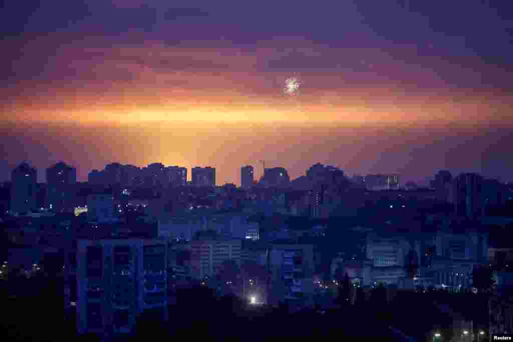 An exploding missile lights up the night sky over Kyiv during a Russian air raid.