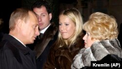 Russian President Vladimir Putin (left) speaks with Ksenia Sobchak (center) during a visit to her father's grave in 2003. Anatoly Sobchak's widow, Lyudmila Narusova, is on the right. (file photo)