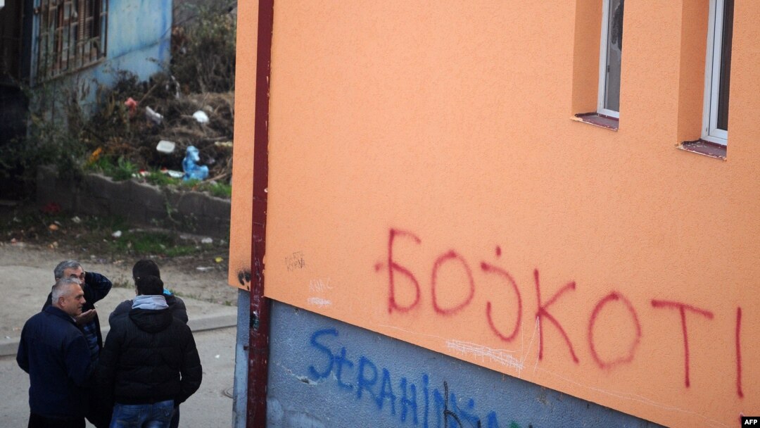 Grupa građana severne Mitrovice pored grafita koji pozivaju na bojkot kosovskih izbora, novembar 2013.
