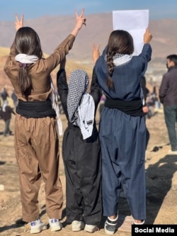 Three Iranian girls in November 2022 show their solidarity with protesters in the city of Mahabad following the death of Mahsa Amini in police custody.