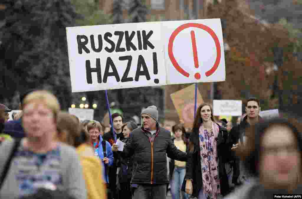 Протестующий на антиправительственном марше держит плакат с надписью «Русские идите домой». Фраза была широко распространена революционными венграми во время восстания 1956 года, которое в конечном итоге было подавлено Москвой.