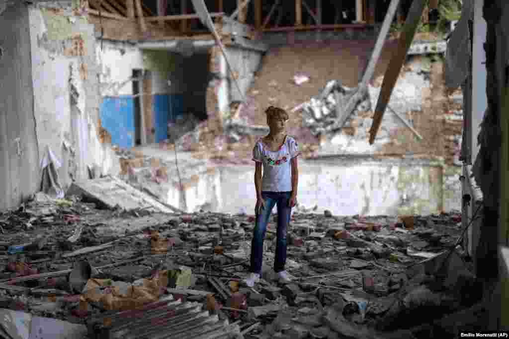 Sofia Klyshnia, 12, stands amid the rubble of her former classroom, in the same place where her desk once stood. "It's scary to stand in the destroyed part of the class where I once studied," she said.