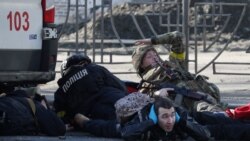 Ljudi se skrivaju dok se oglašava sirena za vazdušni napad, u blizini stambene zgrade oštećene nedavnim granatiranjem u Kijevu, Ukrajina, 26. februara 2022.
