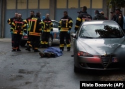 Tűzoltók egy holttest mellett állnak a támadás helyszínén a montenegrói Podgoricától mintegy 30 km-re nyugatra, Cetinjében, 2022. augusztus 12-én.