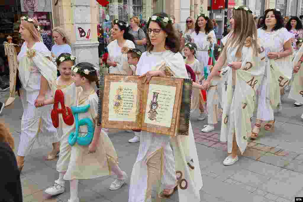 Locals of Ruse in northern Bulgaria wear gowns featuring Cyrillic characters. Bulgarians turned out en masse on May 24 to honor the legacy of Saints Cyril and Methodius during a holiday named after the two brothers.
