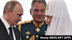 Президент России Владимир Путин (слева), патриарх Московский Кирилл (справа) и министр обороны Сергей Шойгу беседуют во время посещения морского храма в День ВМФ