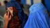 Pakistan -- Afghan refugee women wait to board trucks at the United Nations High Commissioner for Refugees (UNHCR) repatriation centre on the outskirts of Peshawar, July 28, 2016