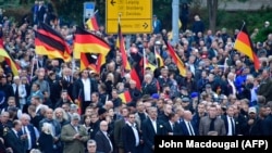 Demonstrators wave German flags during a protest organized by the right-wing populist Pro Chemnitz movement, the far-right Alternative for Germany (AfD) party, and the anti-Islam Pegida movement on September 1 in Chemnitz.