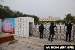 Daşary ýurt žurnalistleri Hytaýyň Sinjiang sebitinde bir binanyň daşyny surata alýar. Bu ýer 2020-nji ýylyň başlarynda 'täzeden terbiýeleýiş' desgasy hökmünde anyklandy, ýöne häzir hytaý hökümeti onuň weteranlar bilen gatnaşyklar býurosydygyny we ol ýerde hökümetiň başga edara-jaýlarynyň ýerleşýändigini aýdýar