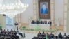Türkmenistanda täze partiýa ak pata berenler prezident Berdimuhamedowyň ägirt uly suratynyň astynda göwnihoş ýagdaýda ornaşdylar. Aşgabat, 21-nji awgust, 2012.
