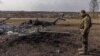 Український військовий стоїть біля збитого російського літака, Харківська область, березень 2022 року 