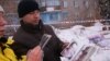 Алексей Алексеенко, родственник погибших в результате обрушения дома, показывает фото погибшей девушки с полугодовалым ребенком. Шахан, 2 января 2017 года.