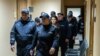 Полицейские ведут Евгению Гуцул на заседание суда Буюкан.