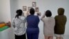 Thai women at a property that houses prospective surrogate mothers. On the walls are pictures of babies born to the resident mothers.