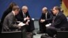 Борыс Джонсан і Ўладзімір Пуцін (у цэнтры) у кулюарах бэрлінскага саміту, 19 студзеня 2020 году