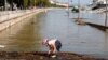 A child plays at the edge of a flooded riverside road in downtown Budapest.