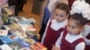 Девочки рассматривают книги на экомарафоне "Знатоки природы". Караганда, 22 мая 2014 года.