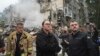 Ukrainian Prime Minister Yulia Svyrydenko (center) and Interior Minister Ihor Klymenko (right) visit the site of a multistorey residential building destroyed by a Russian missile attack in Kyiv on July 31. 