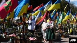 A family prays in front of a grave of a fallen Ukrainian soldier at a military cemetery on Easter Sunday in Lviv.