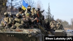 Військовослужбовці України їдуть на бронетранспортерах у звільненому від російських військових місті Тростянці Сумської області, 28 березня 2022 року