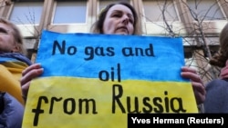 „Fără gaz și petrol din Rusia” scrie pe pancarta unei manifestante în timpul unui miting pentru Ucraina în fața Ambasadei germane din Bruxelles, 11 martie 2022