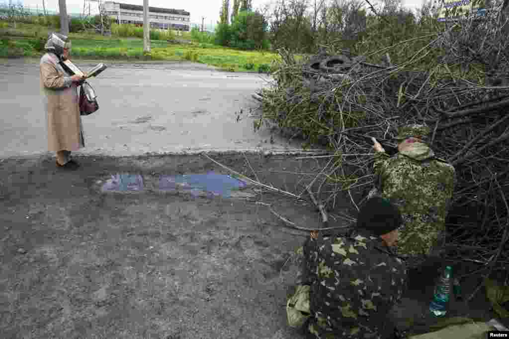 Жінка читає Біблію біля позиції проросійськіх бойовиків на околиці Слов’янська, 5 травня 2014 року
