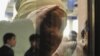 Женщина смотрит в окно в здании суда, где начались слушания по делу о "беспорядках в Жанаозене". Актау, 27 марта 2012 года. Иллюстративное фото.