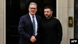 Prim-ministrul britanic Keir Starmer (stânga) dă mâna cu președintele ucrainean Volodimir Zelenski în timp ce îl întâmpină pe treptele de pe Downing Street nr. 10 din centrul Londrei, pe 14 august.