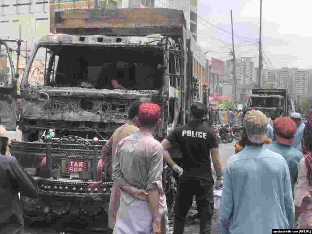 Police investigate after protesters set fire to at least eight trucks in Karachi, Pakistan, on August 10.