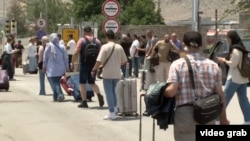 People leaving Iran via the Agarak border crossing with Armenia.