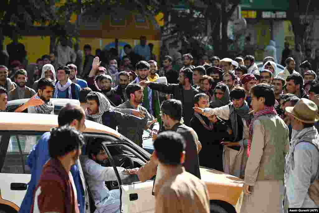 Crowds gather outside a closed branch of a Kabul bank on August 28. Since the Taliban seized power in Kabul, many government buildings, banks, schools, and universities have remained closed. As prices rise, cash is reportedly becoming harder to acquire. 