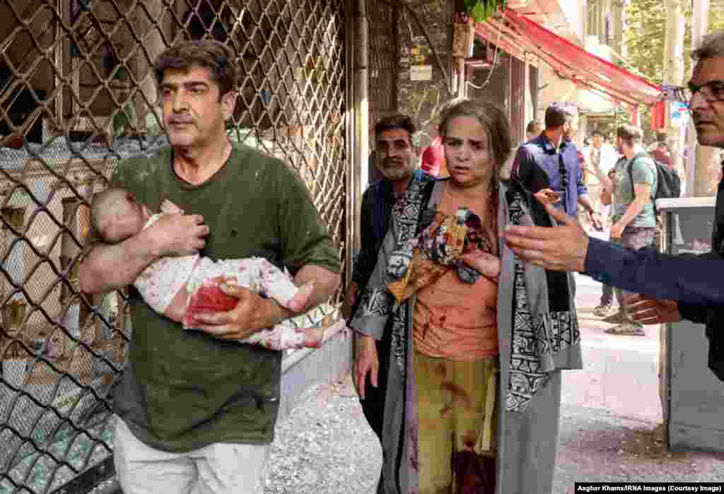 A man carries a baby after a blast in Tehran on June 15. 