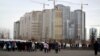 Люди проходят мимо строящегося жилого дома в Астане. 22 марта 2013 года. 