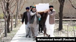 Afghan Sikhs men carry the coffin of one of the victims of a deadly extremist attack on a Sikh religious complex in Kabul that killed dozens of people in late March.