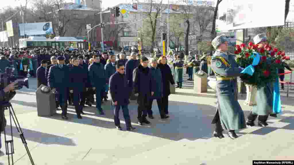 Аким города Алматы Бауыржан Байбек (в центре) и другие чиновники идут возлагать цветы к памятнику «Рассвет свободы».