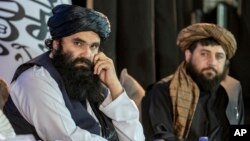 د عکس ښي لور ته د طالبانو د دفاع د سرپرست وزیر محمد یعقوب مجاهد او د عکس چپ لور ته د طالبانو د کورنیو چارو سرپرست وزیر سراجالدین حقاني