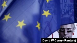 A poster depicting Russian President Vladimir Putin is seen behind an EU flag during a rally by the Czech Republic's Ukrainian community following Russia's invasion of Crimea, in Prague in 2014.