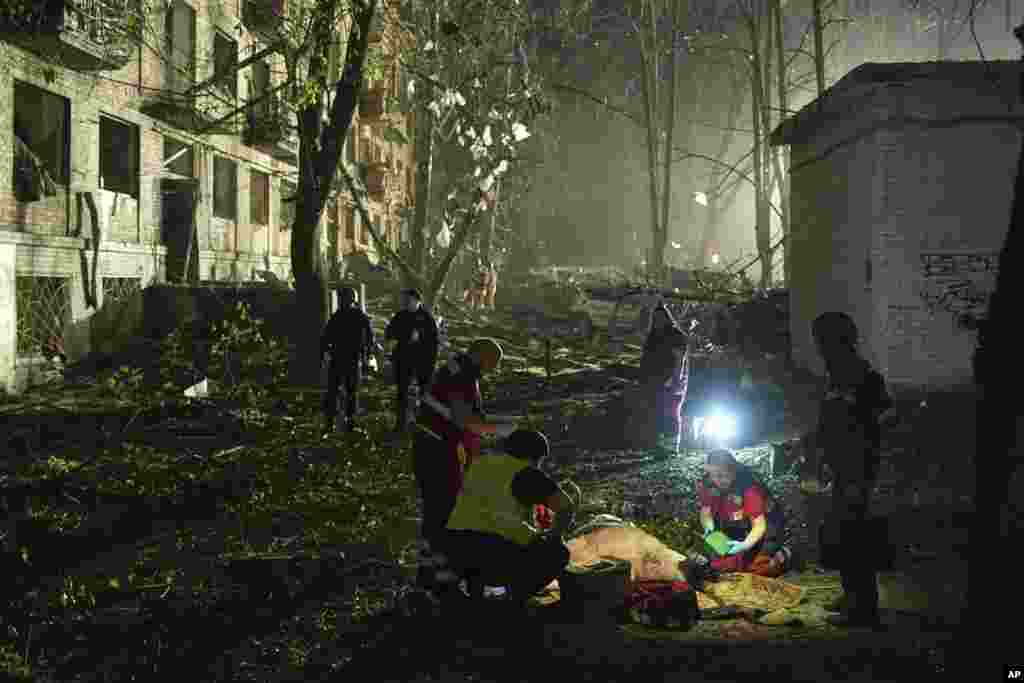 Ukrainian medics treat an injured man after a Russian ballistic missile attack in Kyiv.