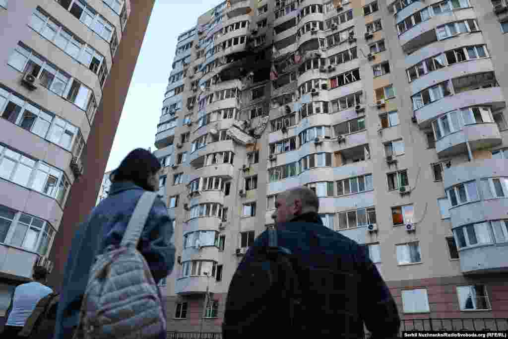 Local residents look at the aftermath of the Russian strike.