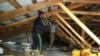 Рабочие ремонтируют чердачную крышу в доме, пострадавшем в результате взрыва отопительного котла. Поселок Шахан Карагандинской области. 23 июня 2017 года. 