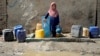 An Afghan child collects water from a public water pump in Kabul (file photo)