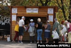 People receive free food at an outdoor "soup kitchen."