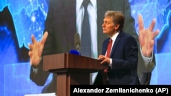 RUSSIA – Kremlin spokesman Dmitry Peskov, bottom, looks on as Russian President Vladimir Putin speaks via video call during a news conference in Moscow, December 17, 2020