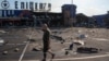 A man on July 26 walks past a shopping mall that was hit by a Russian missile in Ukraine's Dnipro region.